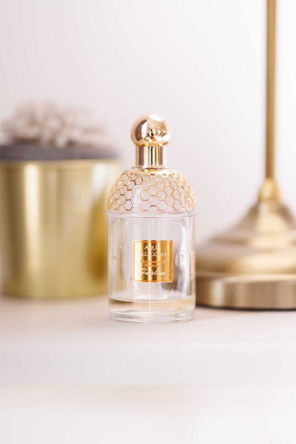 Elegant gold and glass bell jar cloche decorative pieces arranged in a minimalist composition on white surface.