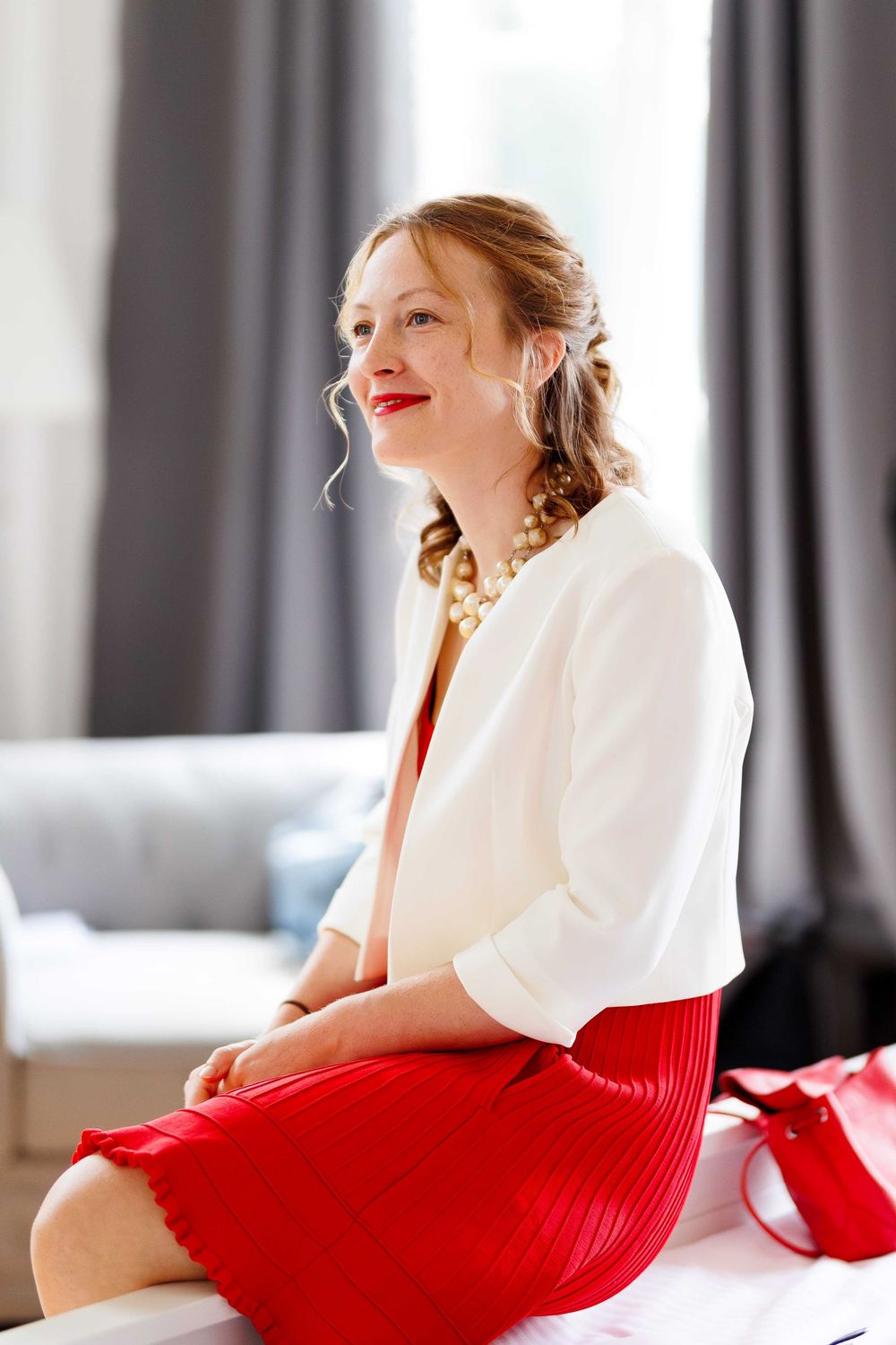 Stylish fashion portraits featuring a white blouse and red dress in an elegant indoor setting.