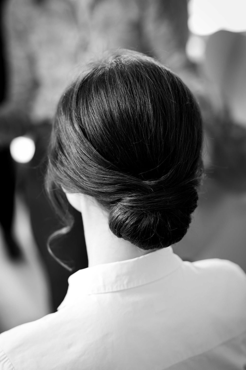 Elegant black and white photo showing a sophisticated low bun hairstyle from behind.