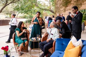 Wedding guests relaxing on outdoor patio furniture during reception.