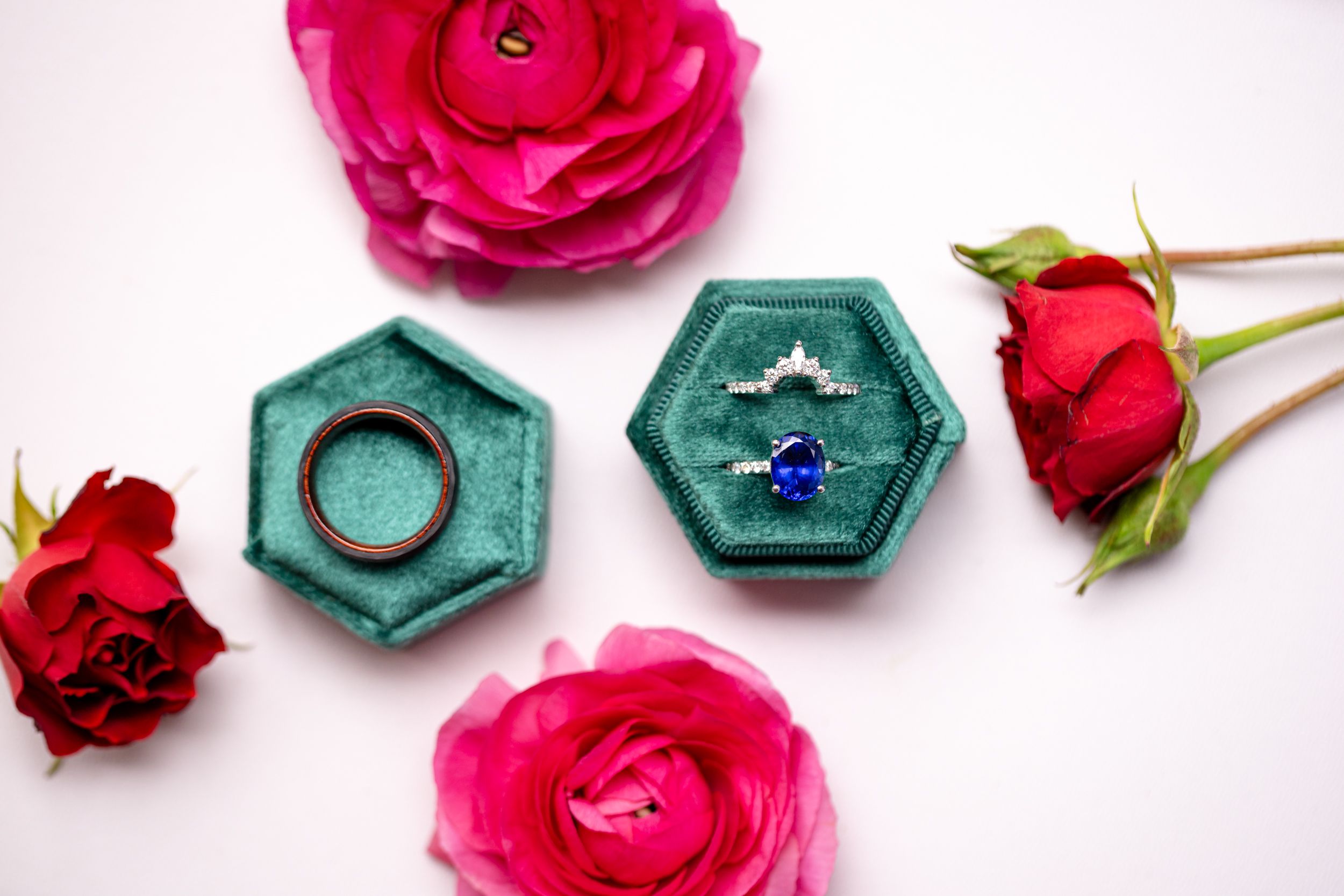 Pink and red roses arranged with teal hexagonal ceramic pieces against a white background.