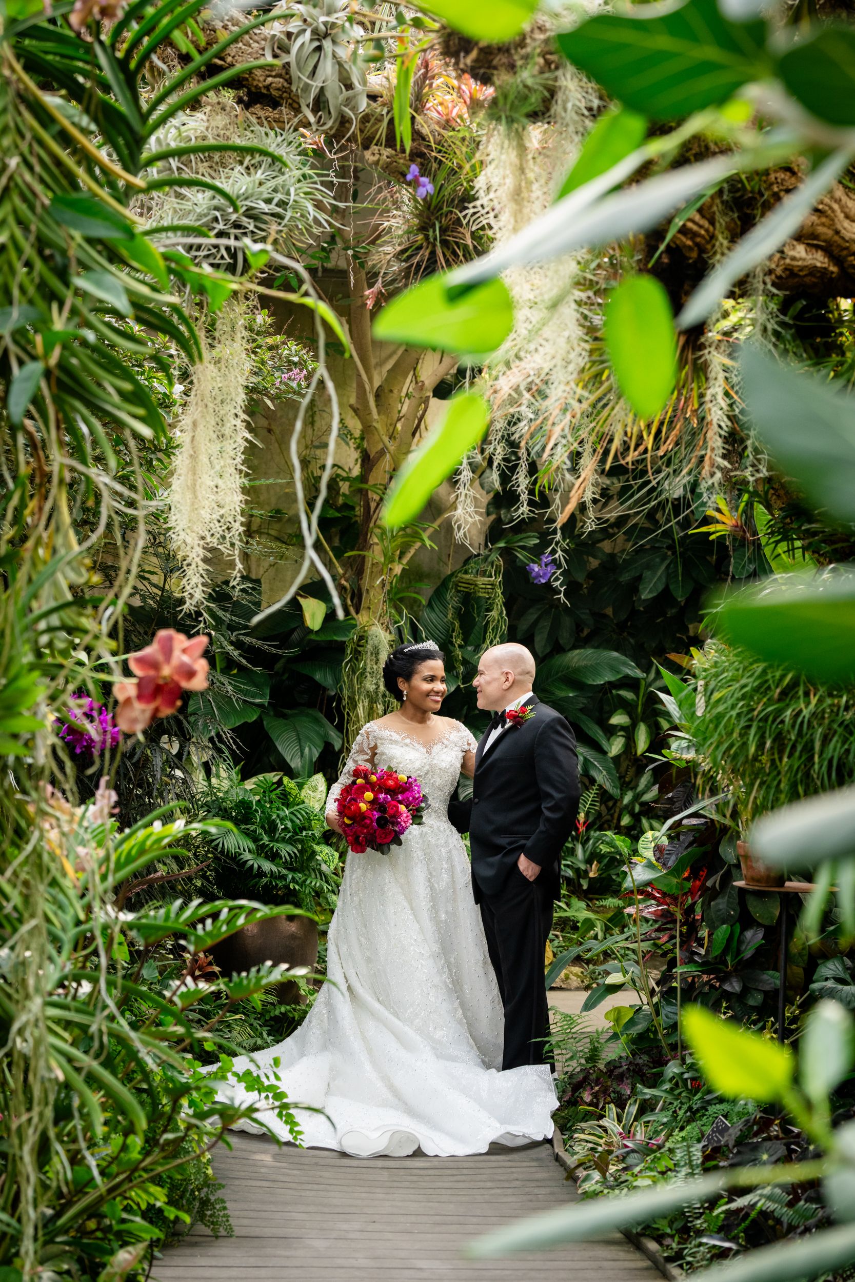 Wedding portraits captured in a beautiful greenhouse setting surrounded by exotic plants and flowers.