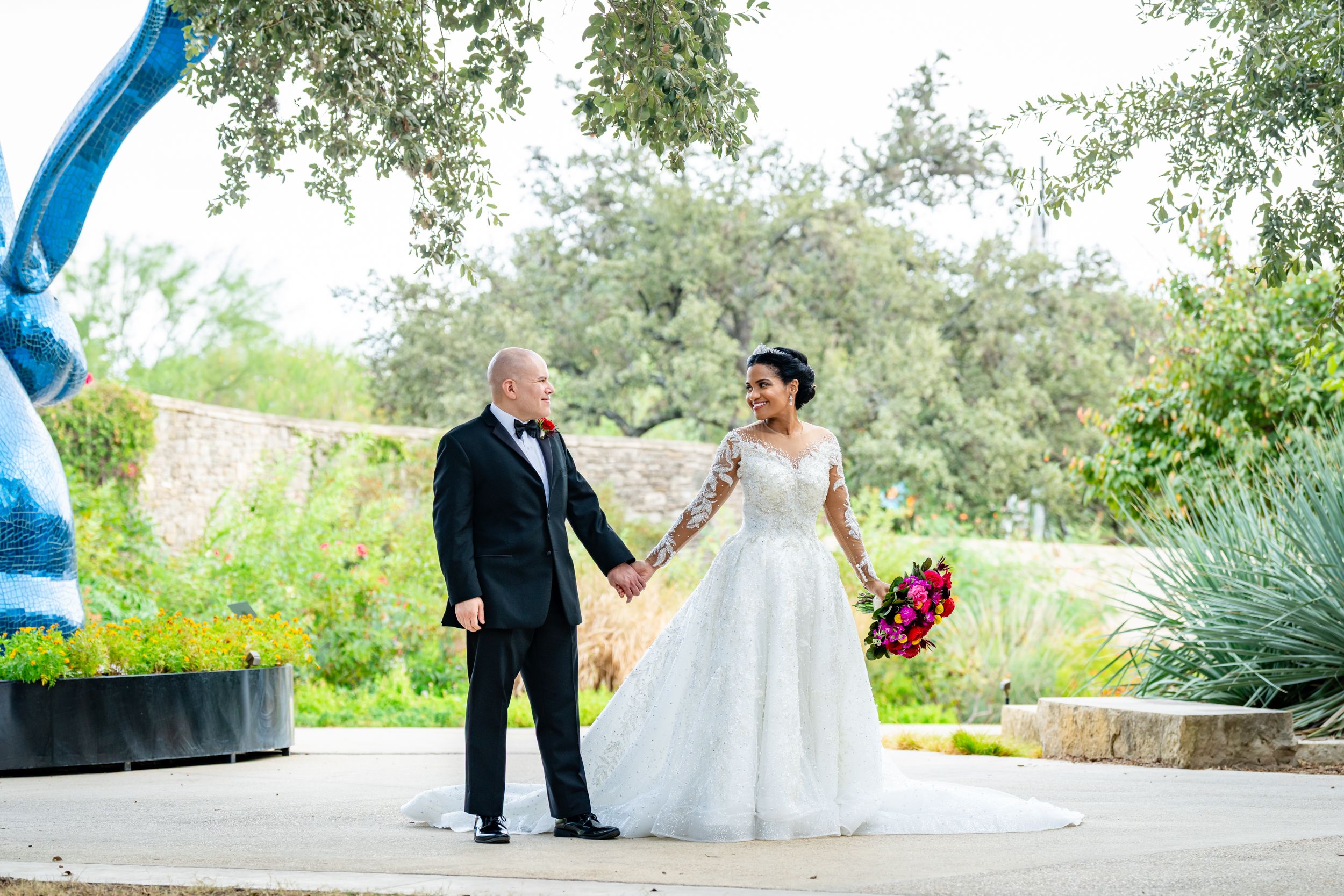 Outdoor wedding venue with lush greenery and stone pathway leading to ceremony area.