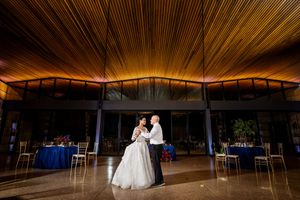 An empty ballroom with dramatic wooden ceiling beams and ambient lighting creates an elegant atmosphere.