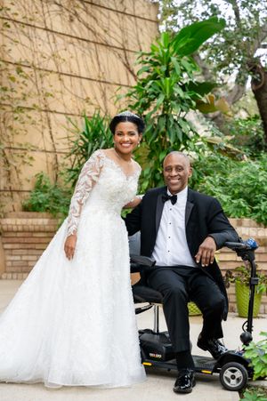 Wedding portraits in a lush garden setting with a white gown and black tuxedo.