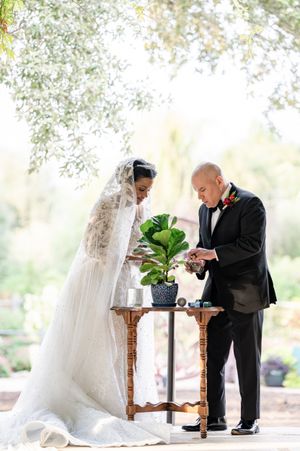 Wedding couple examining details at a decorative table during their first look.