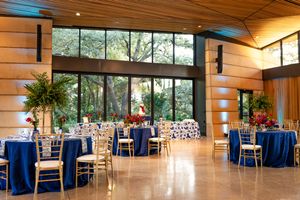 Modern wedding reception venue with wooden walls and blue tablecloths set up for an elegant celebration.