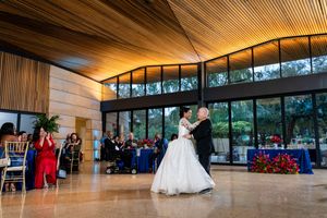 Modern wedding venue with curved wooden ceiling and large windows showcasing a panoramic view of the outdoors.