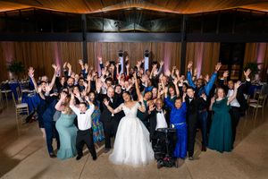 Large group of wedding guests dancing and celebrating on the dance floor.