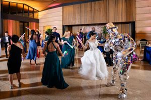 Wedding reception dance party with guests celebrating in formal attire.