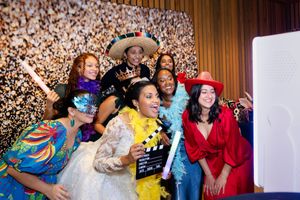 A lively wedding reception shows guests dancing and celebrating in a warmly lit venue with festive decorations.