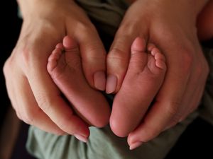 Newborn baby feet in a heart "v" shape during a lifestyle newborn photography session in Calgary, Alberta.