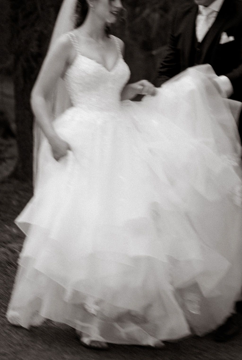A romantic black and white wedding photo sequence showing a couple in formal attire embracing among tall forest trees.