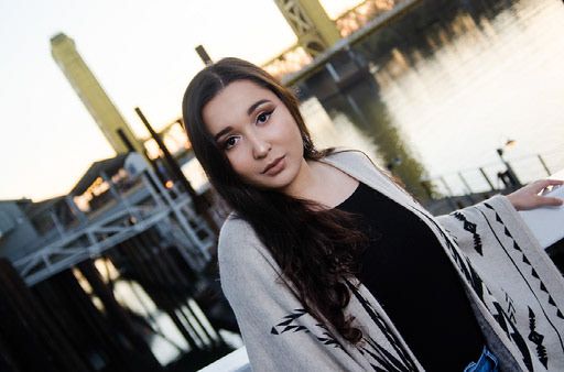 A series of five outdoor portrait photos showing someone in a black and white outfit against an urban background.