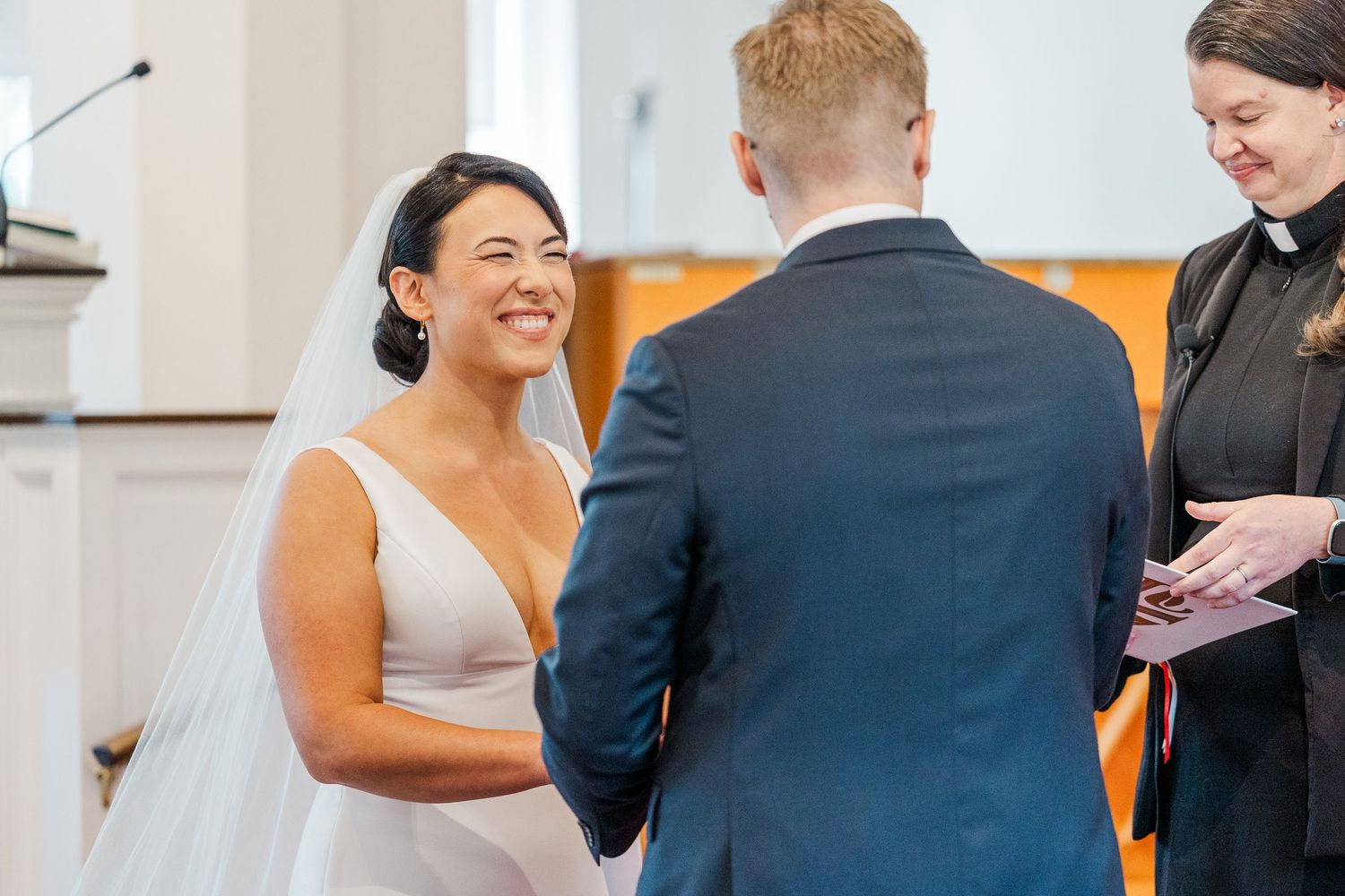 Bride and groom share their first dance at a wedding reception while guests look on with smiles.