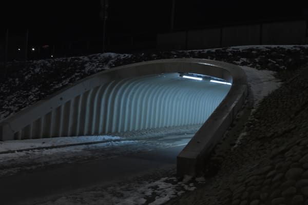 Tunnel at night, lights shining inside the tunnel.