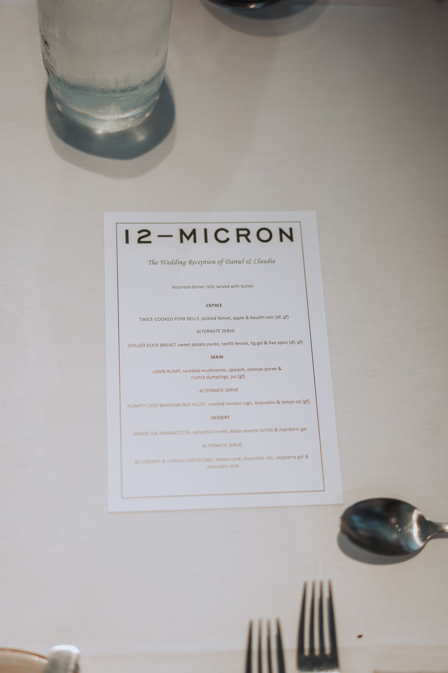 12-Micron restaurant menu on white tablecloth with dining setup.