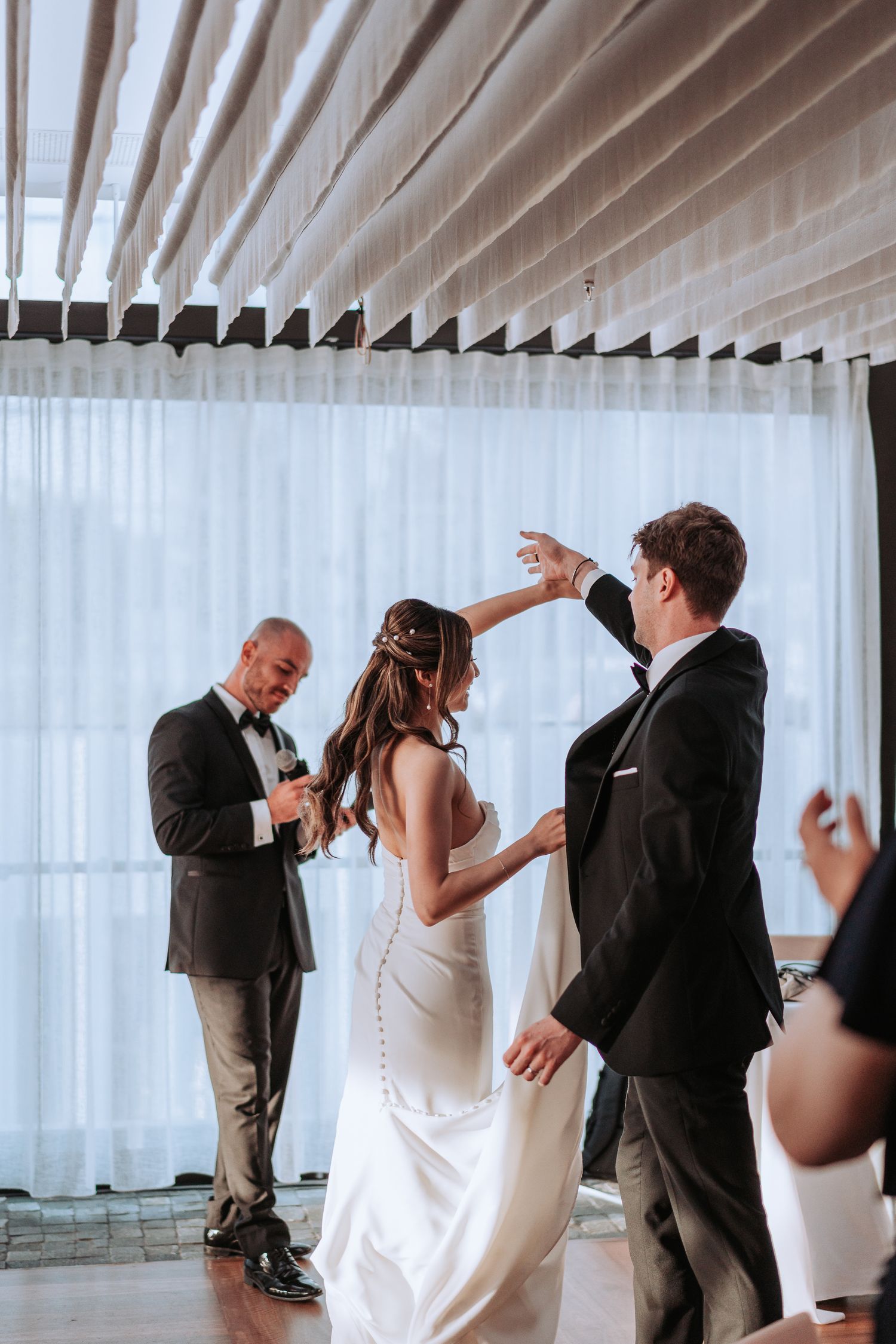 A couple performs a romantic twirl on the dance floor at an elegant wedding reception.