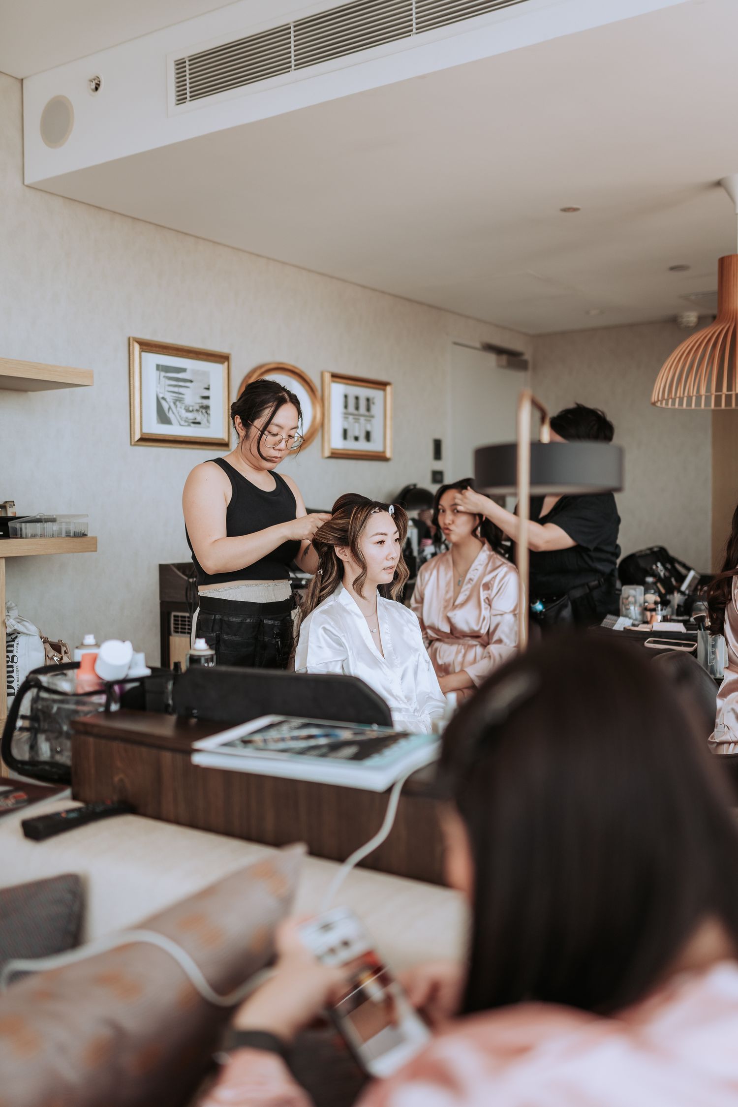 Wedding preparation scene with styling team working in a modern bridal suite.