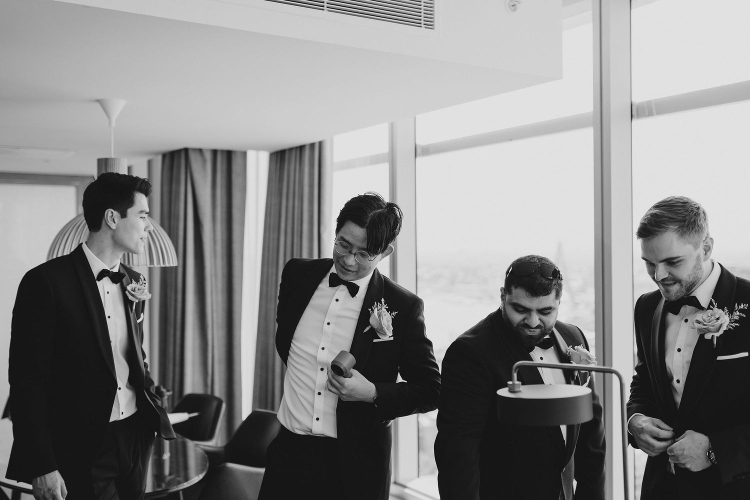 Groomsmen in tuxedos and bowties gather before the wedding ceremony.