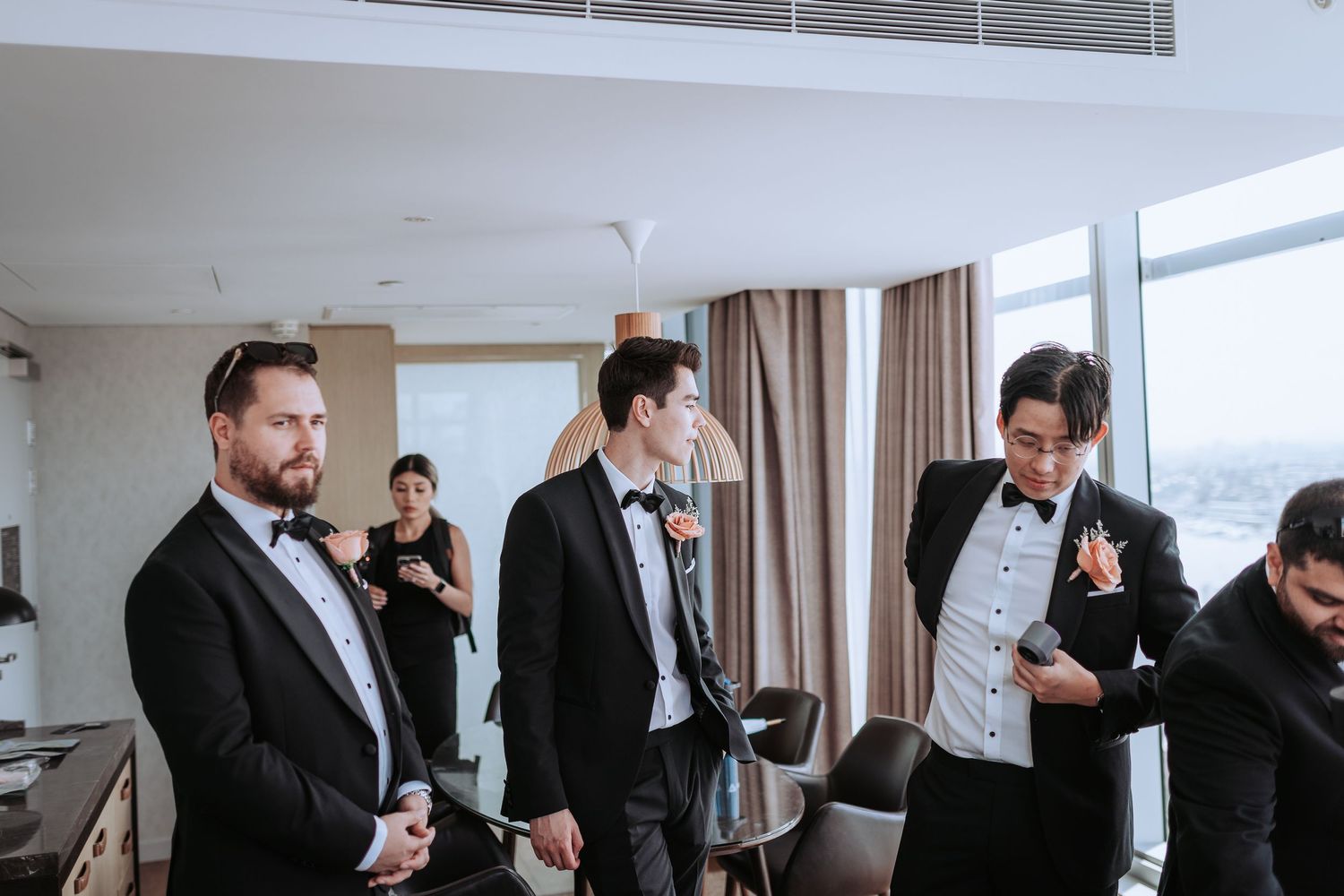Wedding party members in formal black tie attire preparing for the ceremony.