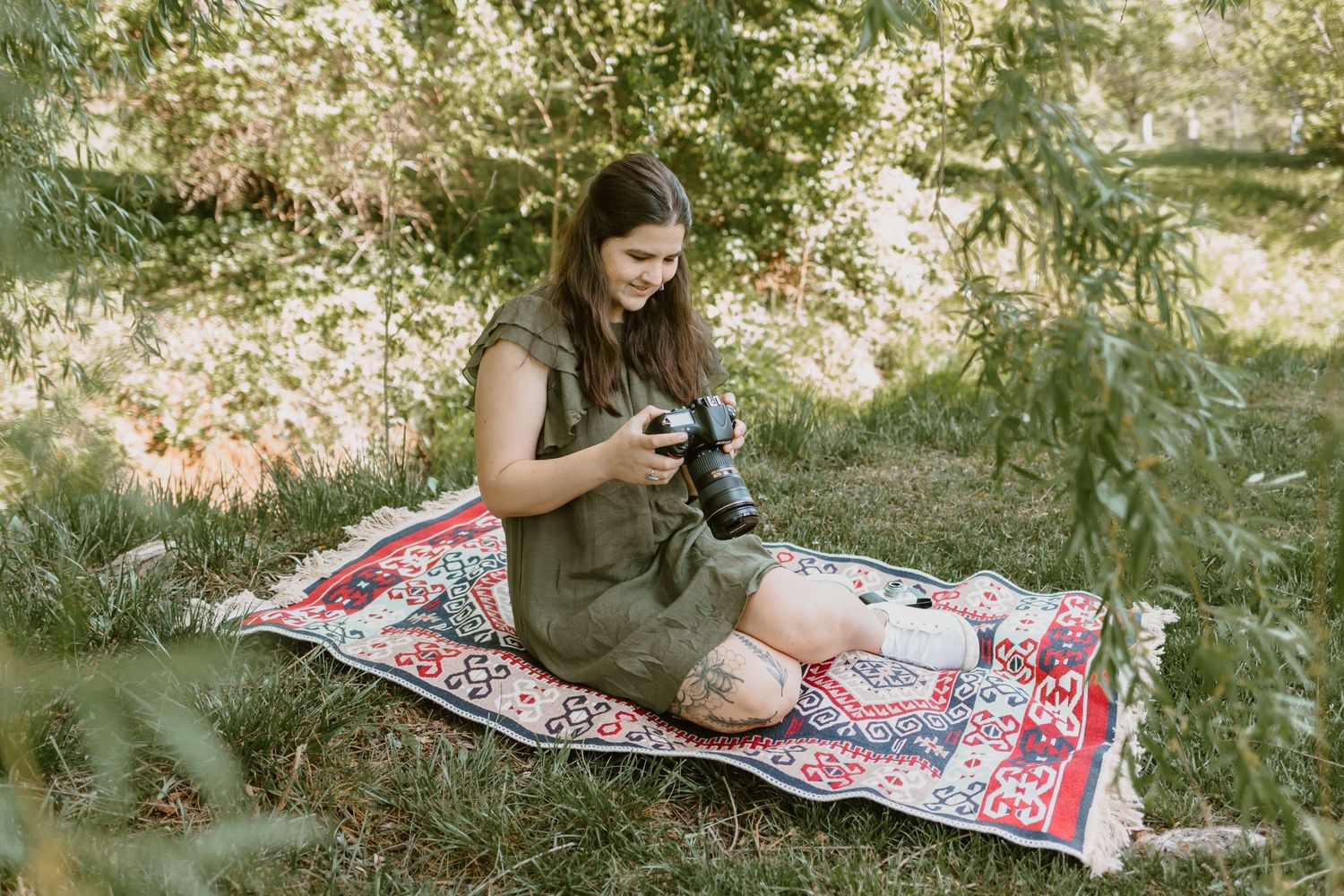 Photographer, Molly, sitting in a park looking through the images on her camera