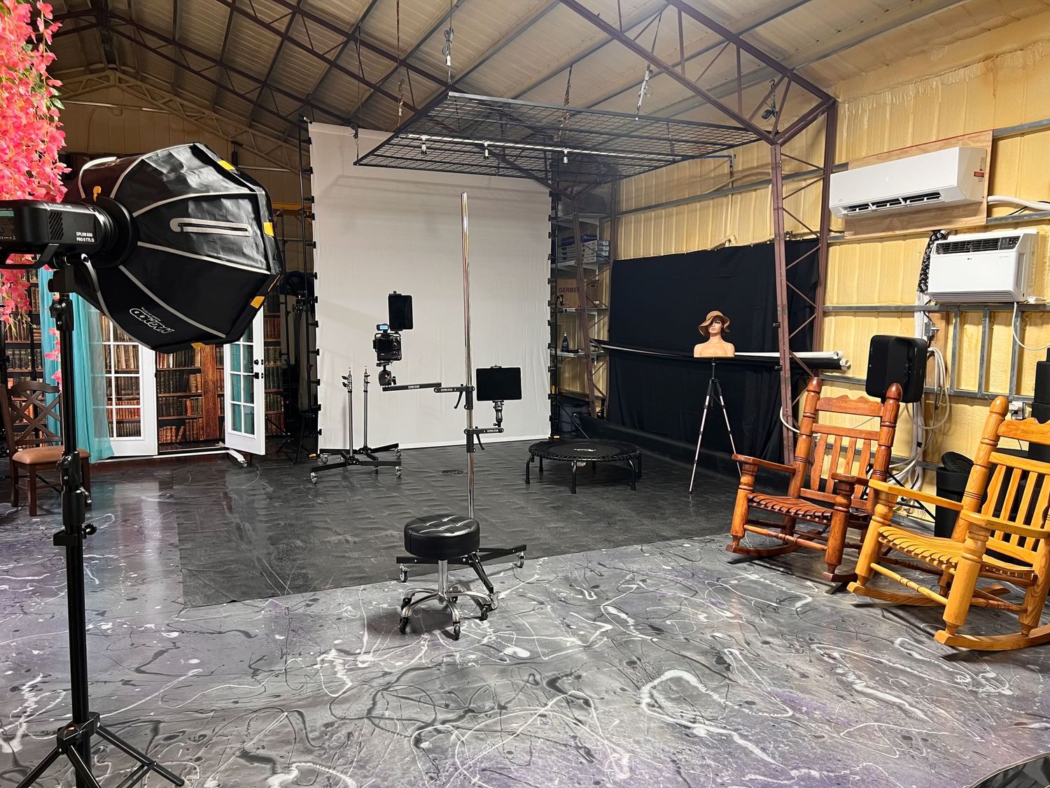 Studio space with wooden rocking chairs, lighting equipment, and professional photography setup.