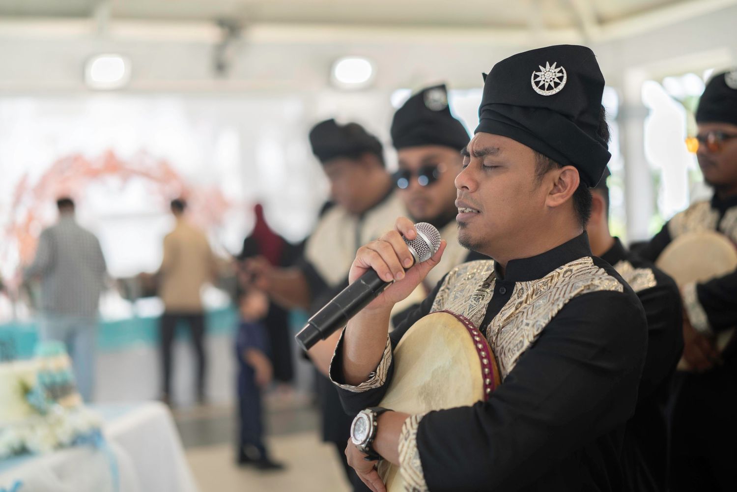 Religious singer in traditional navy uniform performs during a ceremony at an indoor celebration.