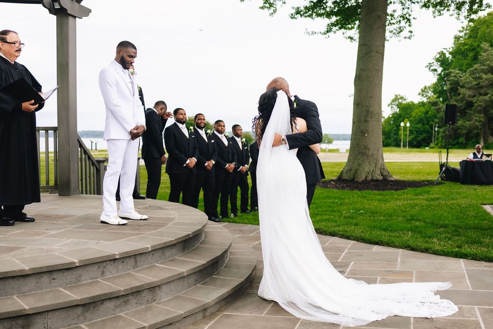 Wedding party lined up on stone steps during an outdoor ceremony.