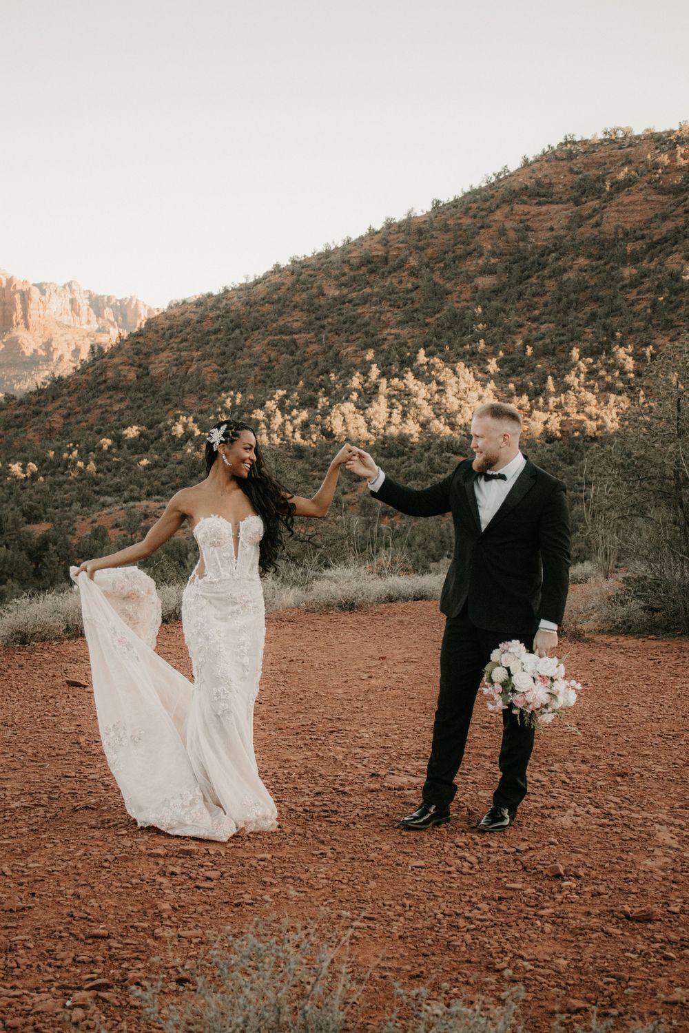 Couple embracing at Lovers Knoll in Sedona Arizona during a cinematic sunset engagement session captured by BOSC Photography.