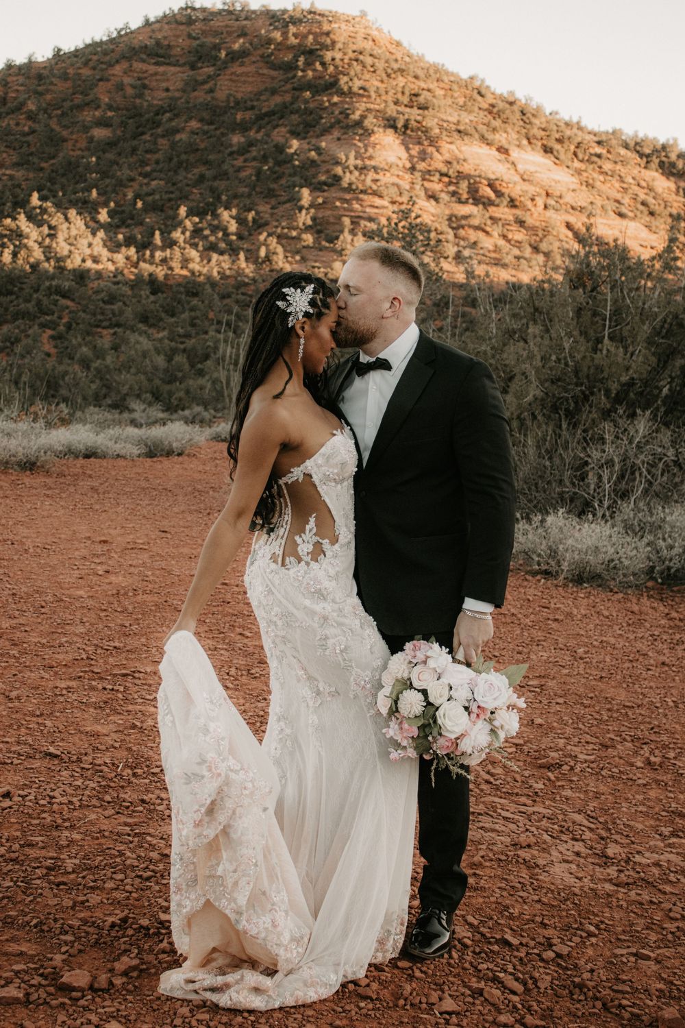 Bride and groom sharing a moment overlooking the red rocks at Lovers Knoll in Sedona Arizona.
