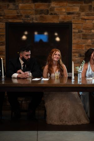 Wedding celebration at rustic venue with brick walls and mood lighting as guests gather at bar.
