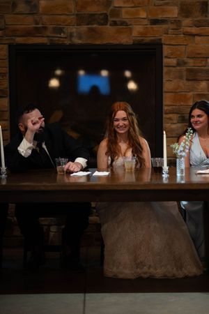 Wedding reception scene at rustic bar with exposed brick walls and ambient lighting.