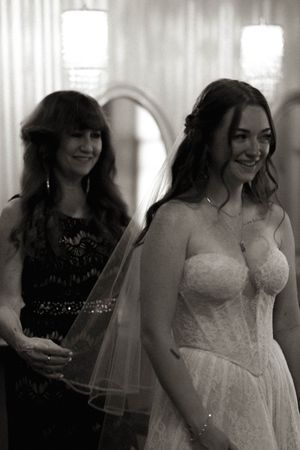 Wedding preparation scene with people in formal attire getting ready indoors.