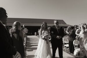 Wedding ceremony guests seated in rows during an outdoor celebration.