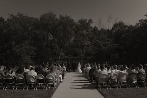 Rows of white chairs set up for outdoor wedding ceremony with natural landscape backdrop.