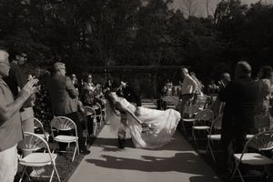 Panoramic view of wedding ceremony setup with seated guests and natural backdrop.