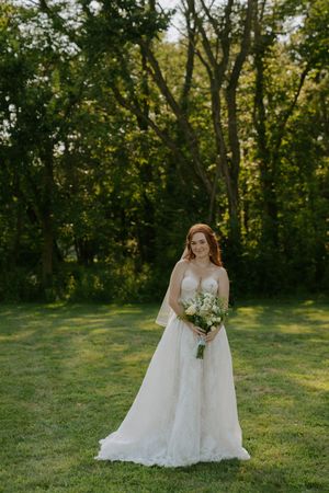 Wedding portraits in natural outdoor setting with golden sunlight filtering through trees.