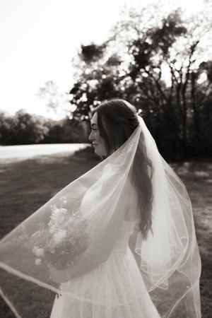 Flowing bridal veil catches the wind in dramatic black and white photos.