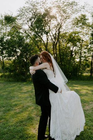 A couple shares an intimate dance moment during their wedding photoshoot in a natural outdoor setting.