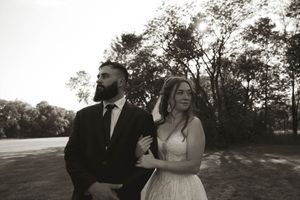 Wedding couple poses for silhouetted portraits against a dramatic sunset sky.