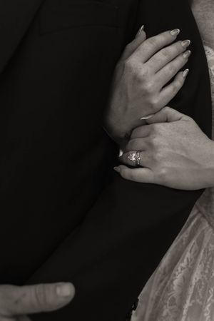 Close-up shots of hands with wedding rings against dark formal attire.