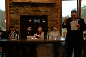 Interior of a rustic venue with exposed brick walls and wooden beams during a wedding reception.