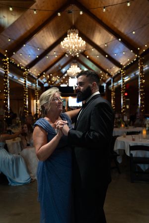 Couples dancing together at an elegantly lit indoor wedding reception venue.