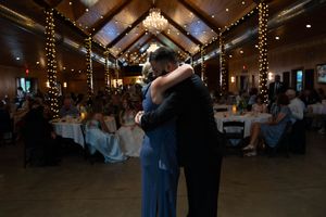 A wedding reception venue decorated with string lights and wooden beam ceilings.