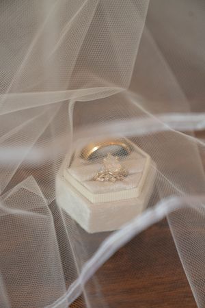 Soft focus shot of wedding veil fabric with decorative elements in the background.