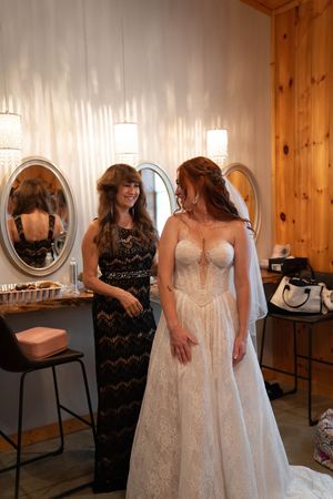 Getting ready scene in a wooden-paneled bridal suite with white wedding dress.
