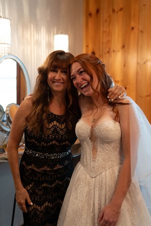 Candid wedding preparation moment in rustic wood-paneled dressing room.