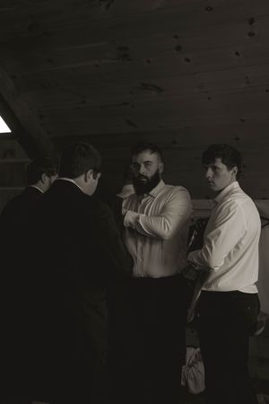 Wedding party dancing in dim lighting at reception venue.