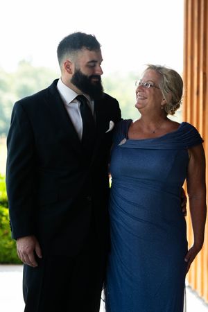 Formal portrait session with wedding party members in black suits and navy dress.
